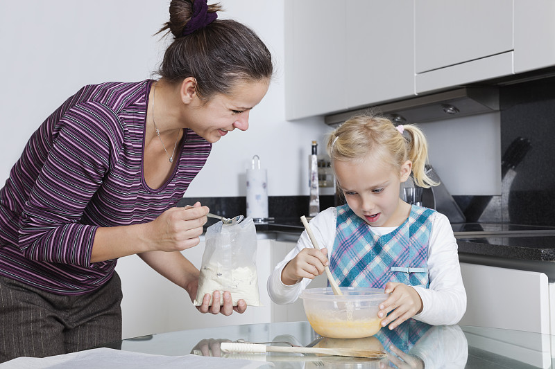 快乐的母亲和女儿一起在厨房烘焙图片下载