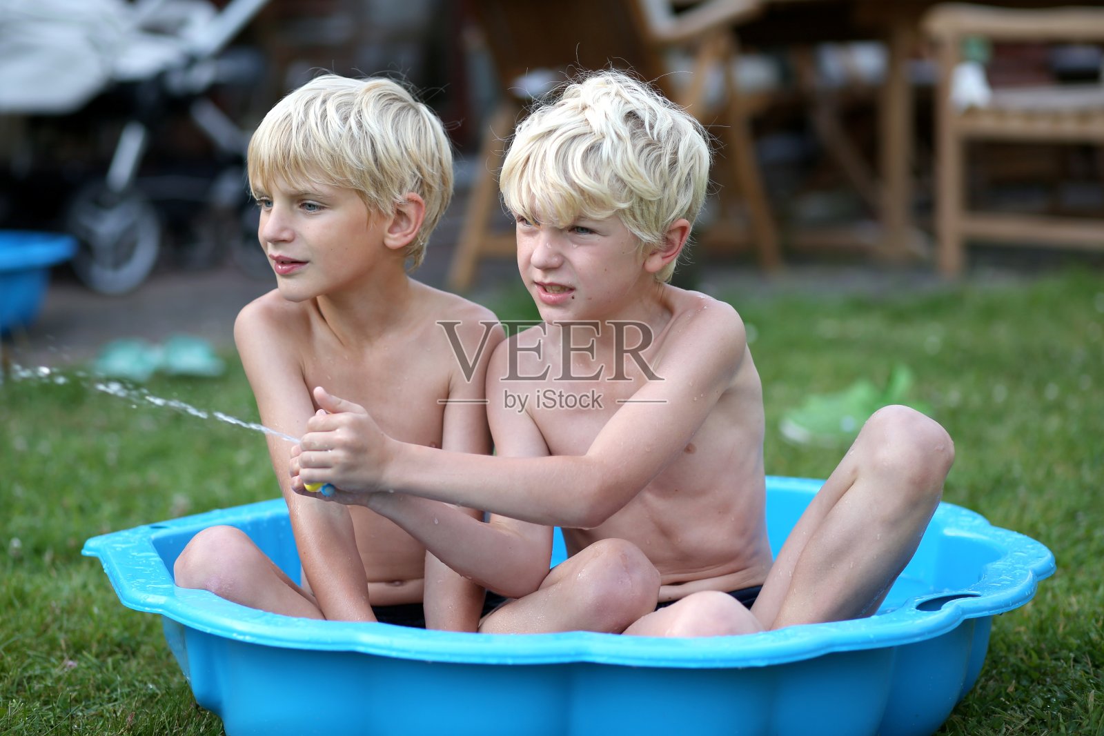 两个兄弟在儿童泳池里玩照片摄影图片