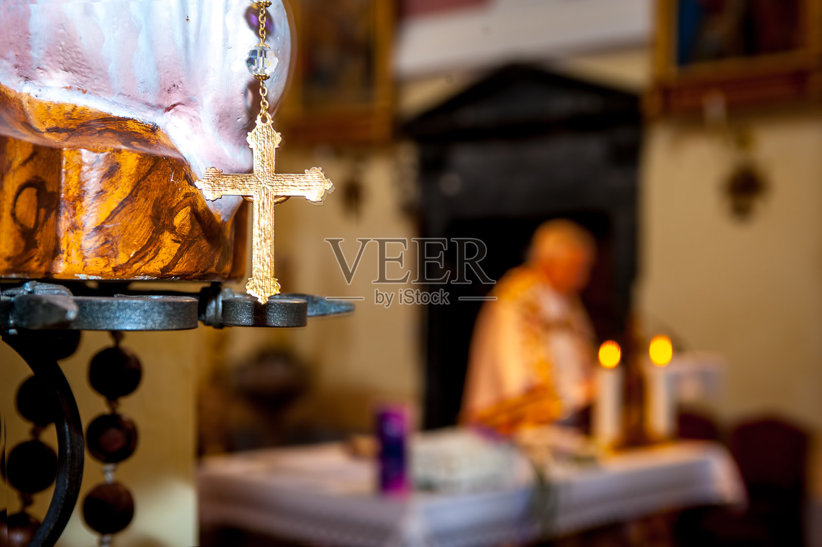 金色十字架近距离，与神父在神圣的弥撒照片摄影图片