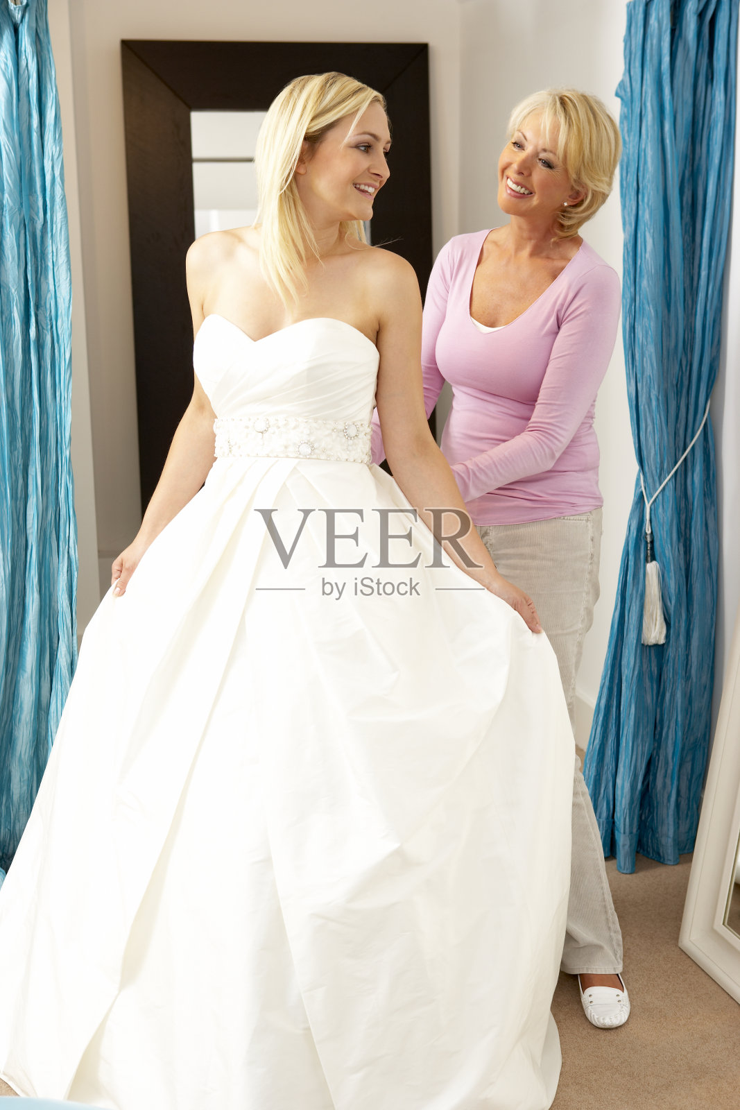 新娘和销售助理试穿婚纱照片摄影图片