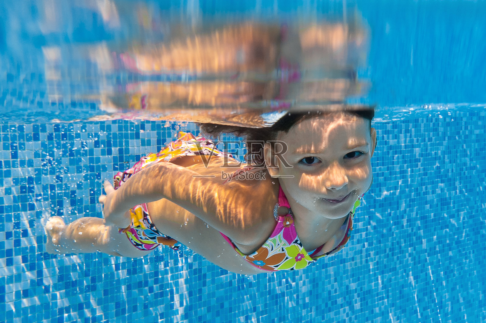 快乐微笑的水下孩子在游泳池照片摄影图片