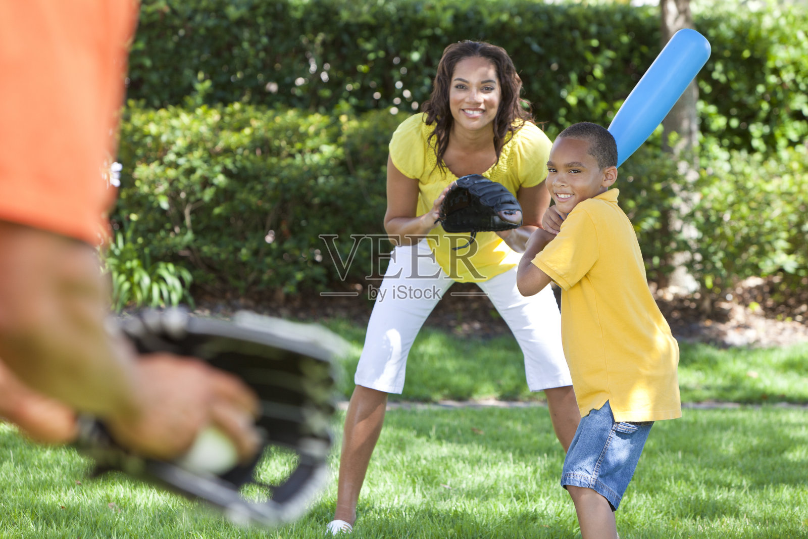 一个非裔美国家庭在院子里打棒球照片摄影图片