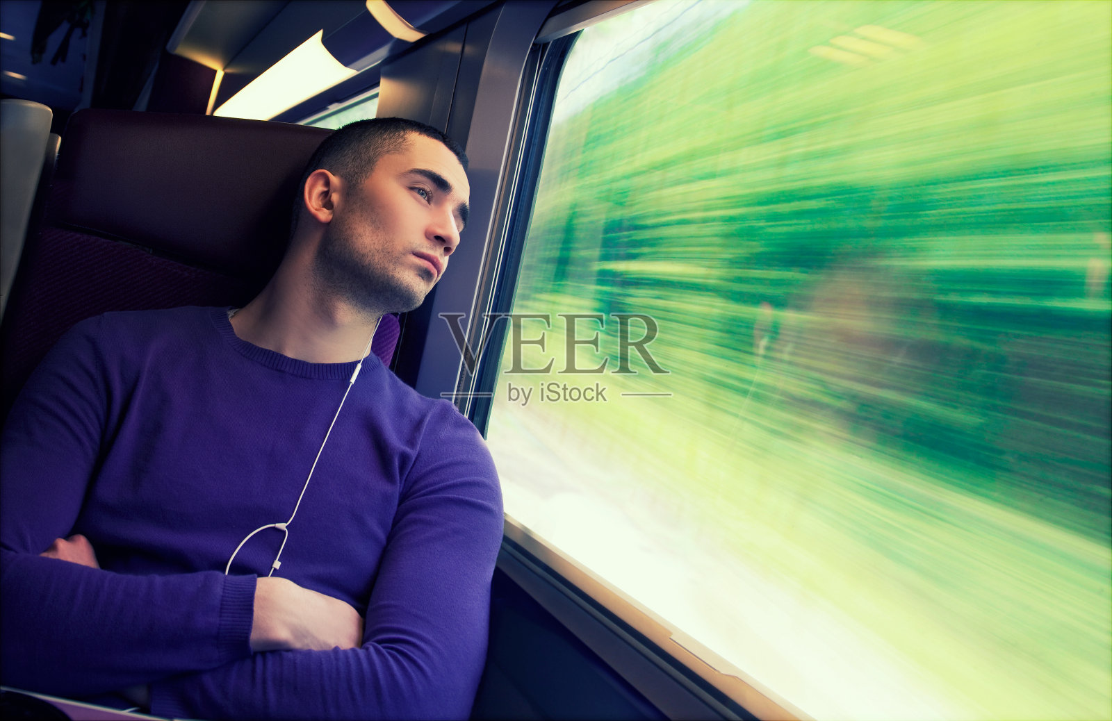 年轻英俊的男人乘火车旅行。照片摄影图片