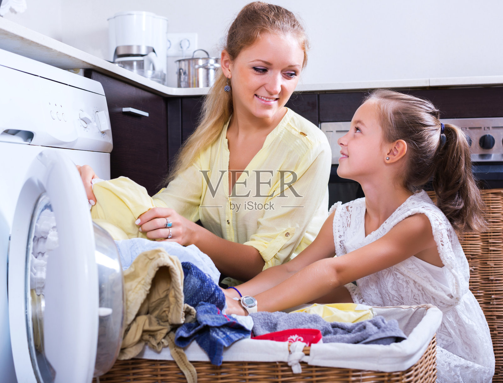家庭主妇和女孩在洗衣服照片摄影图片
