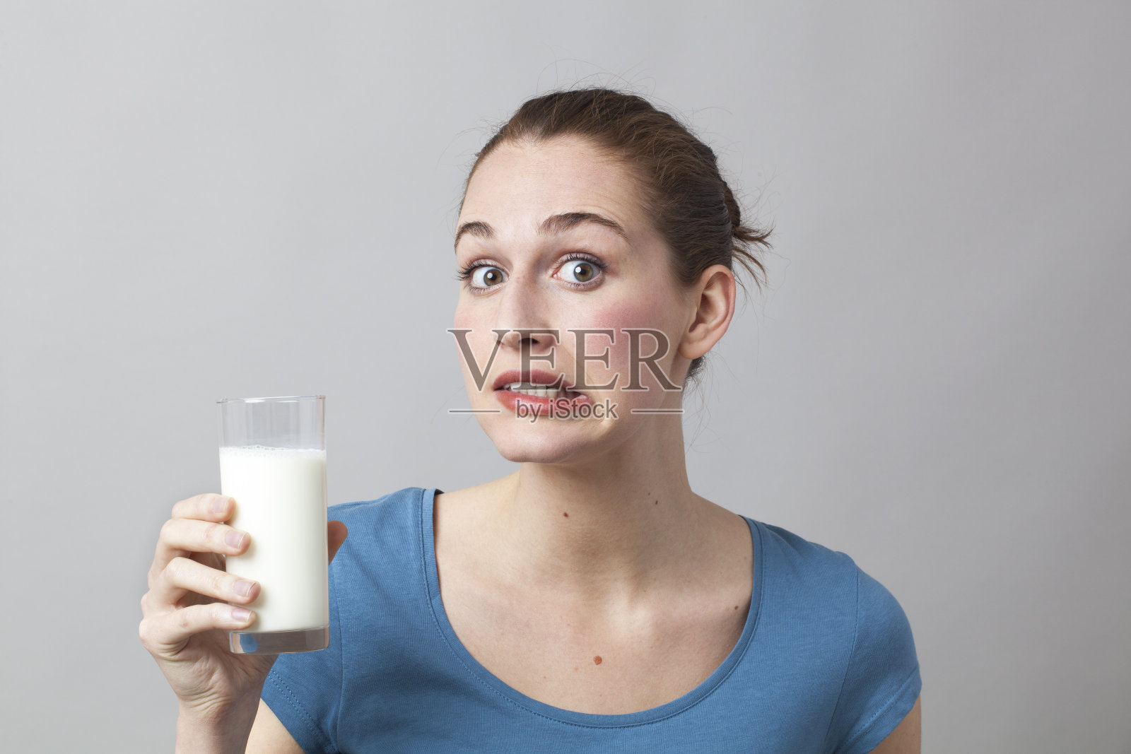惊恐的20岁女孩喝牛奶或豆奶照片摄影图片