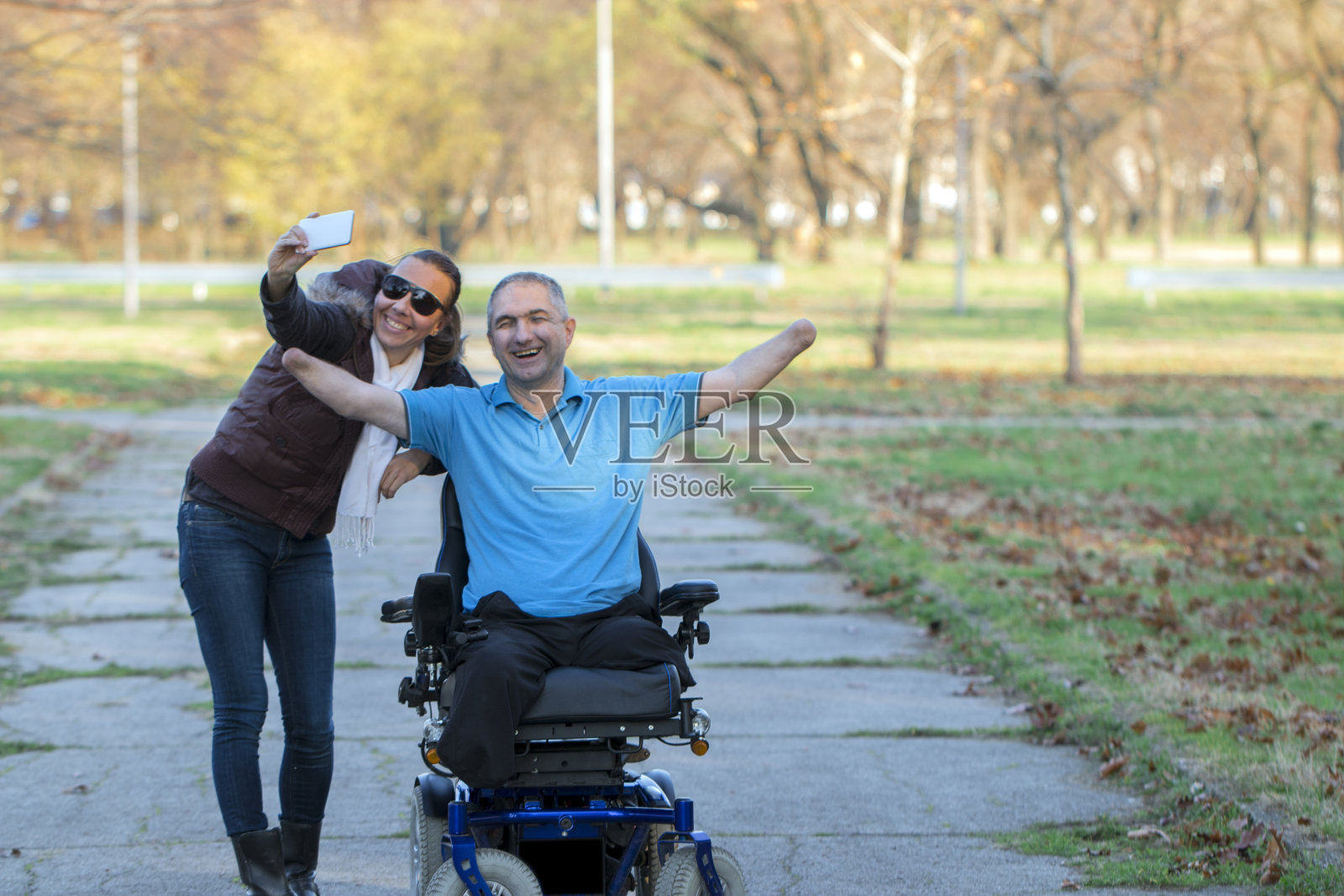 一个坐电动轮椅的人和朋友在一起照片摄影图片