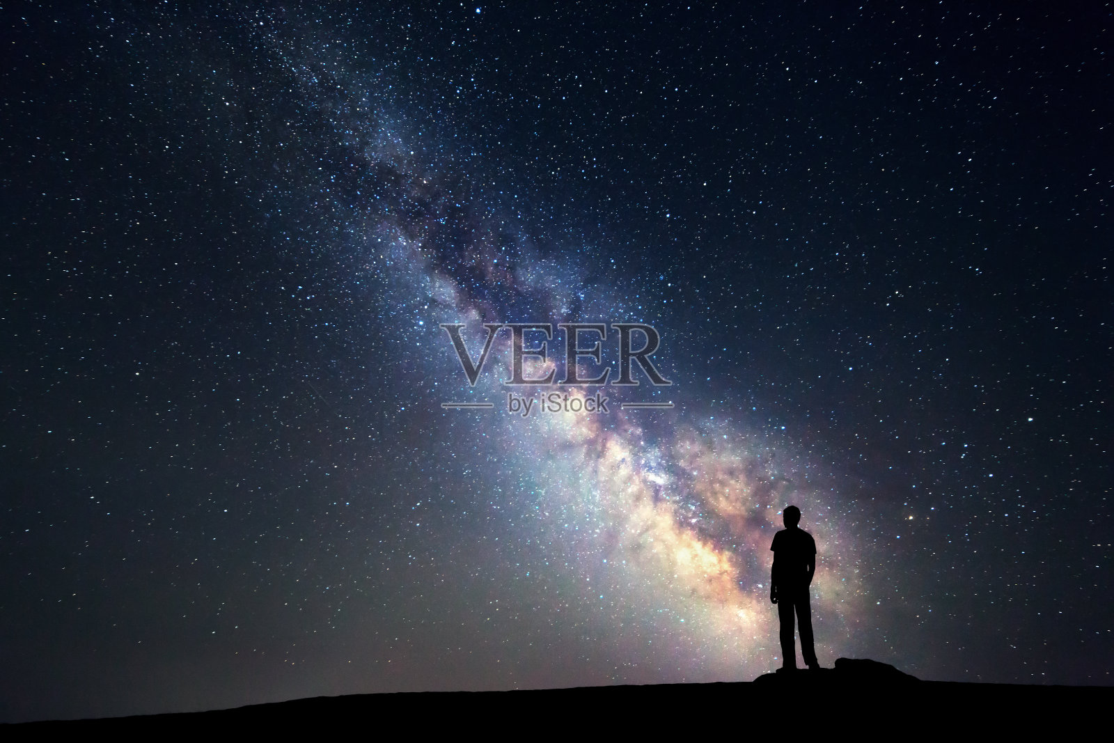 银河系。夜空和一个站立的人的剪影照片摄影图片