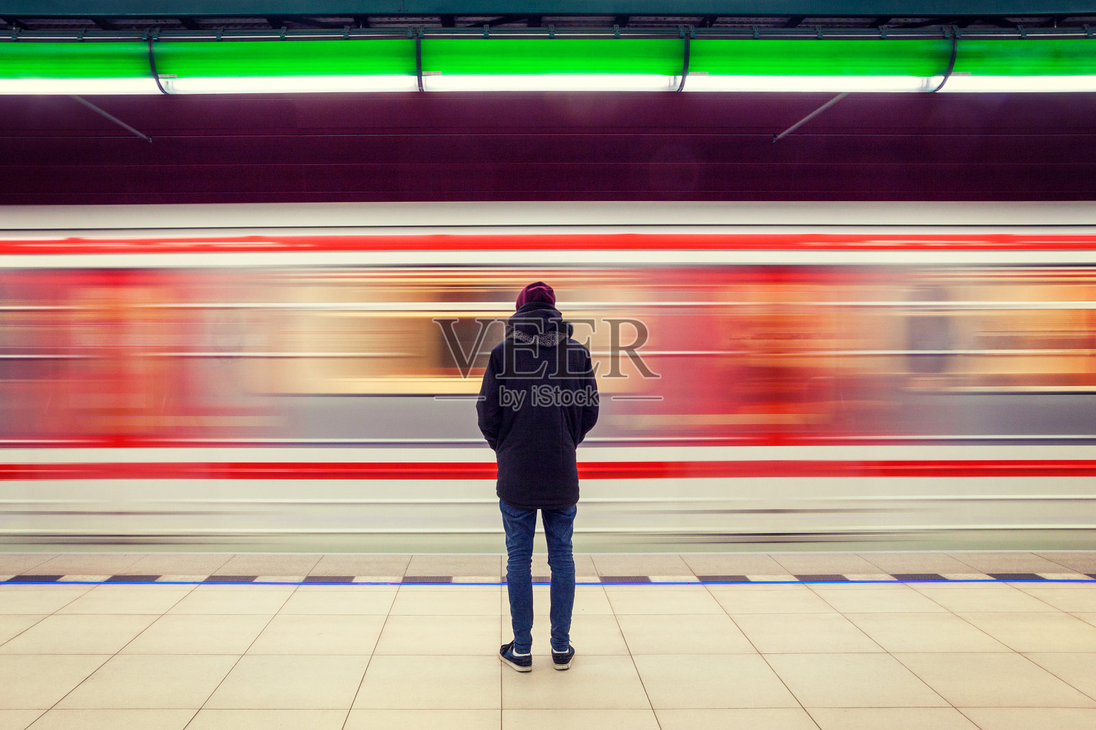 男人在地铁站和移动的火车照片摄影图片