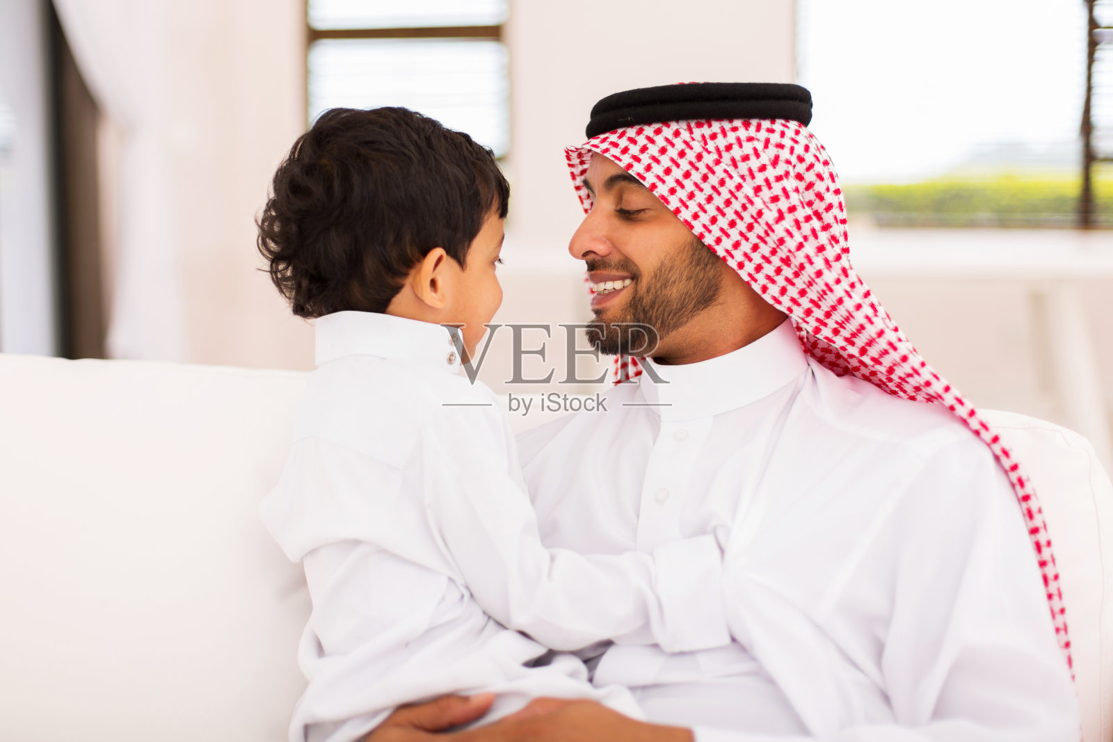阿拉伯父子坐在家里照片摄影图片