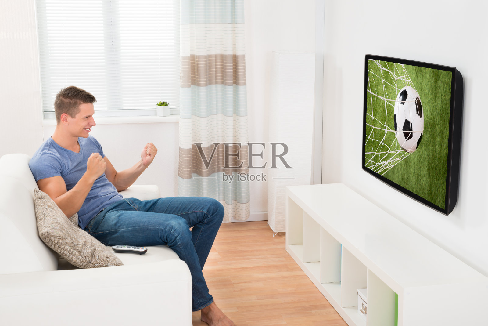 男人在电视上看体育节目照片摄影图片