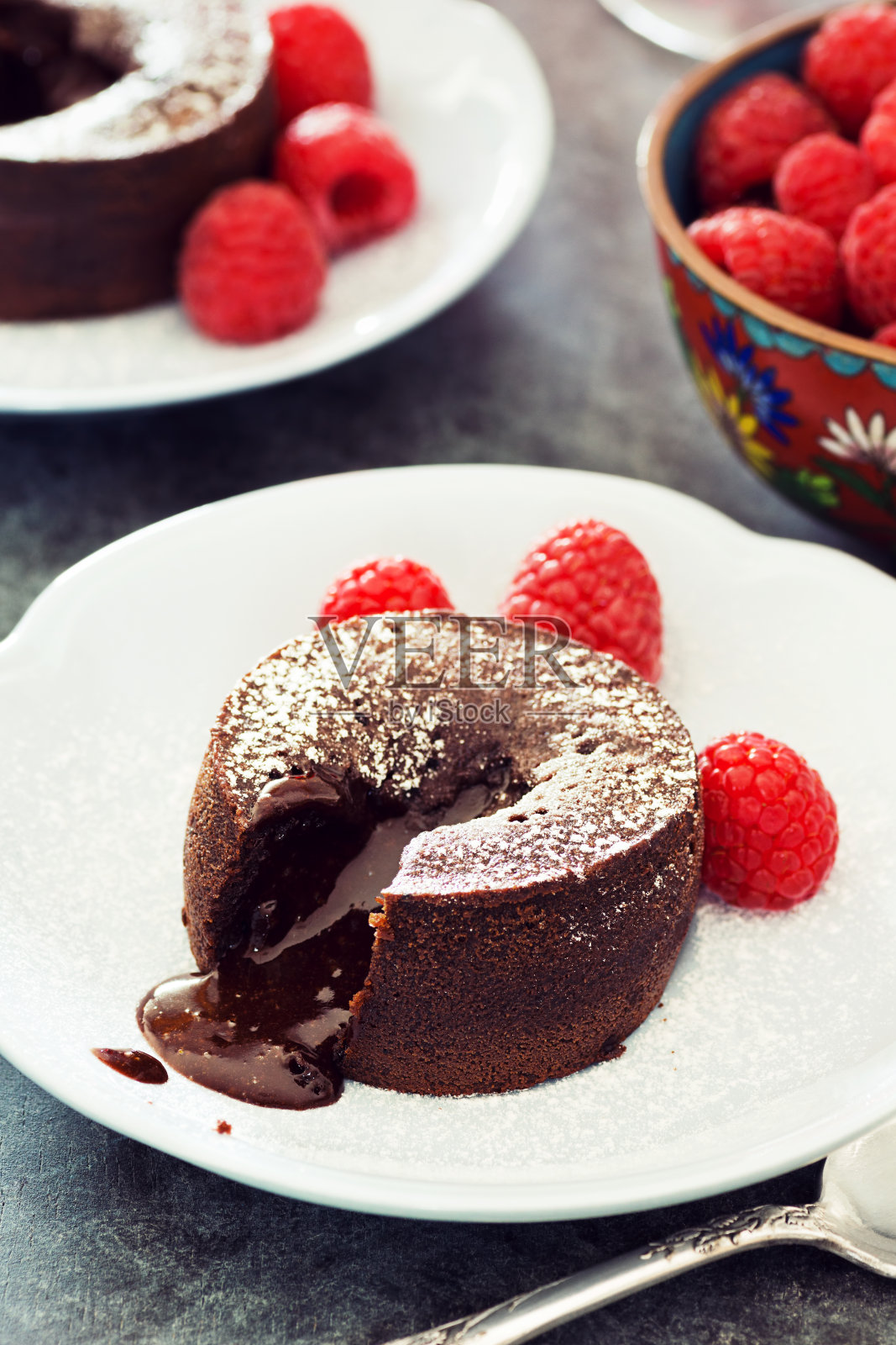 两个烤巧克力熔岩蛋糕加覆盆子照片摄影图片