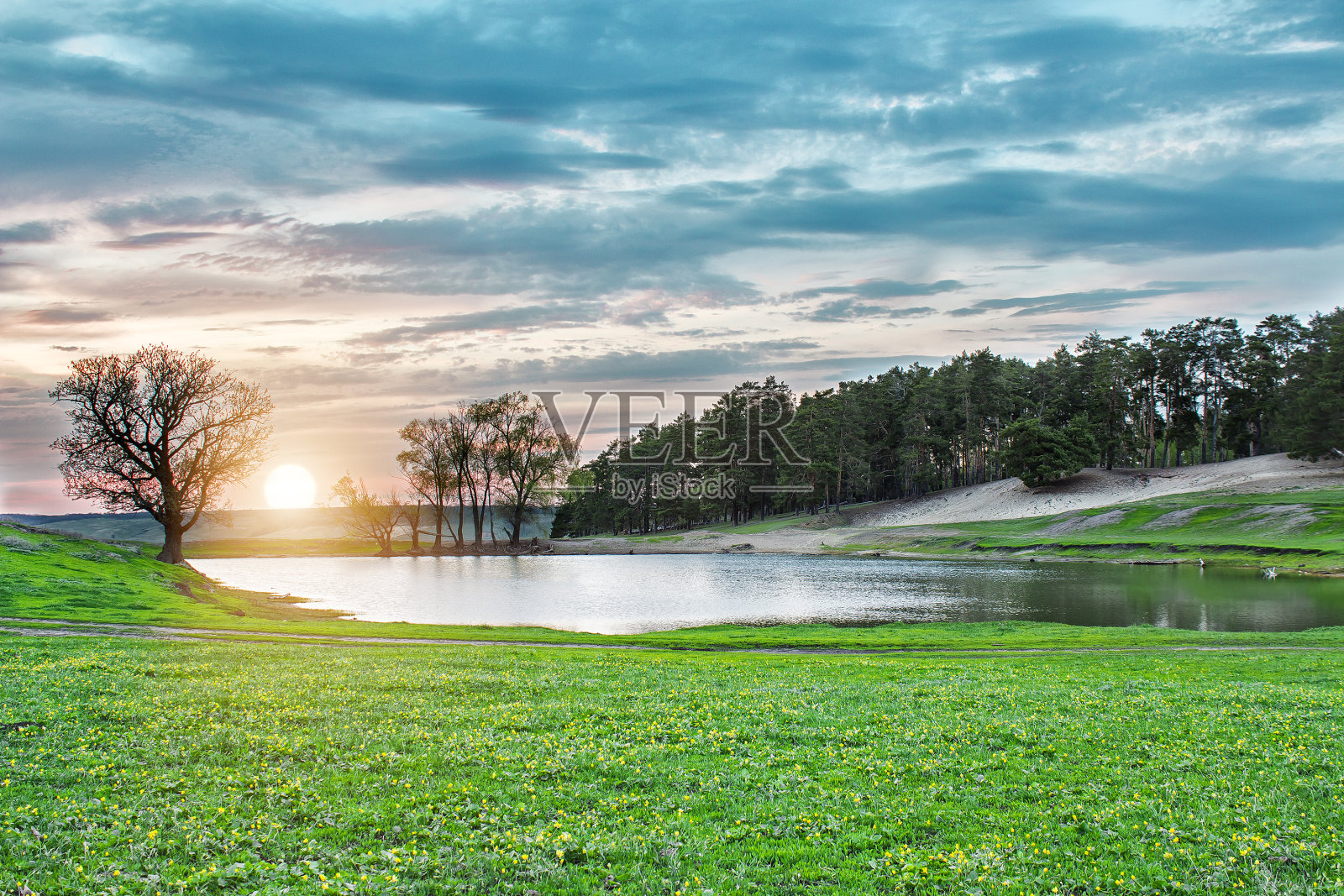 湖在日落在森林中绿色的草地照片摄影图片