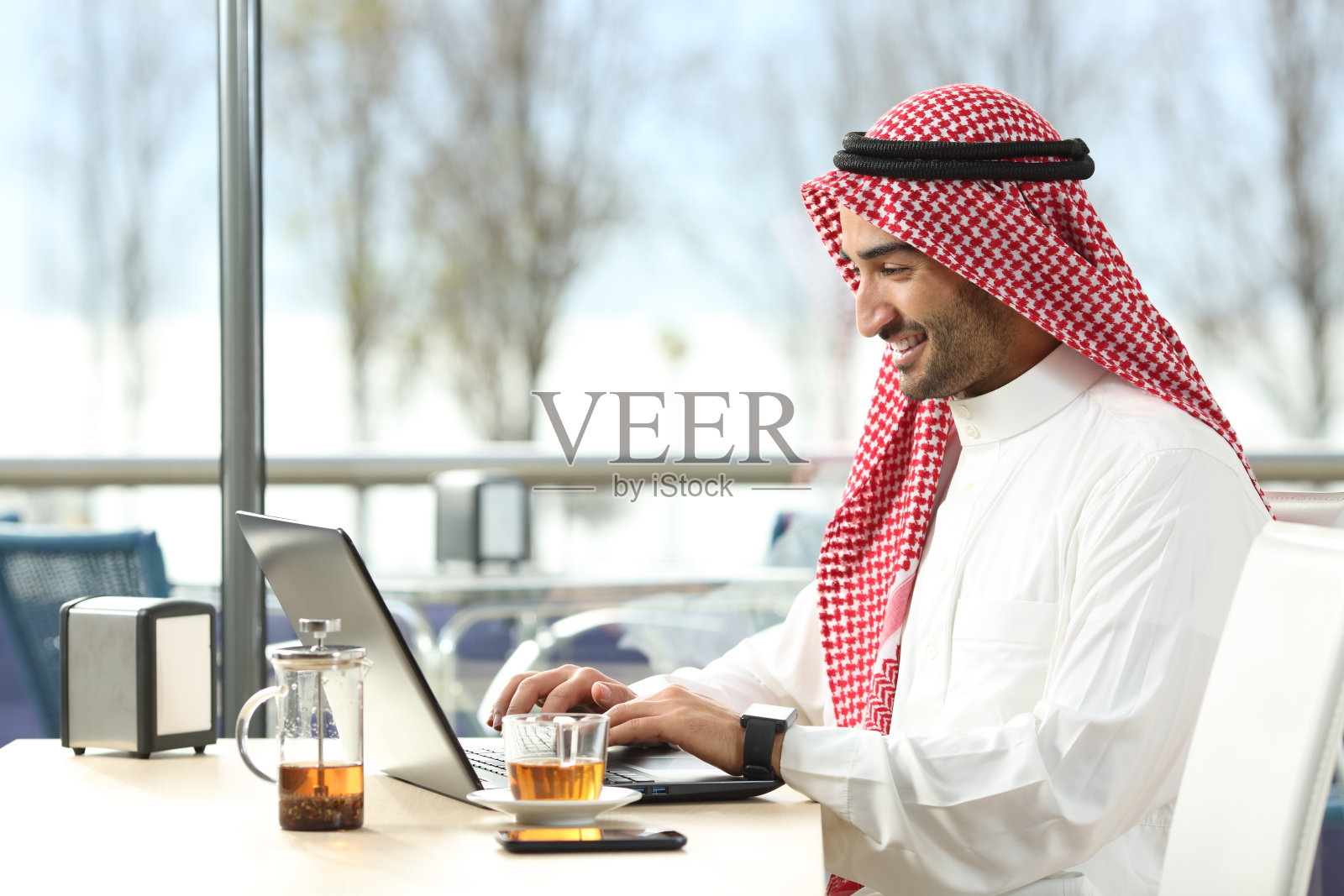 沙特阿拉伯人用笔记本电脑上网工作照片摄影图片