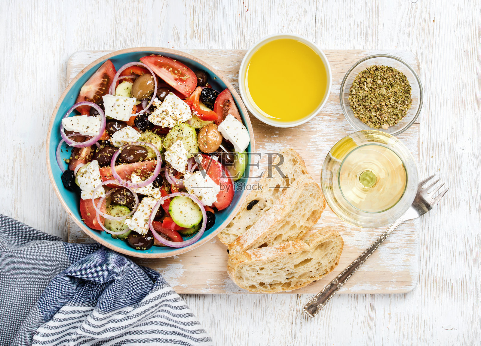 希腊沙拉配橄榄油、面包、香料和白葡萄酒照片摄影图片