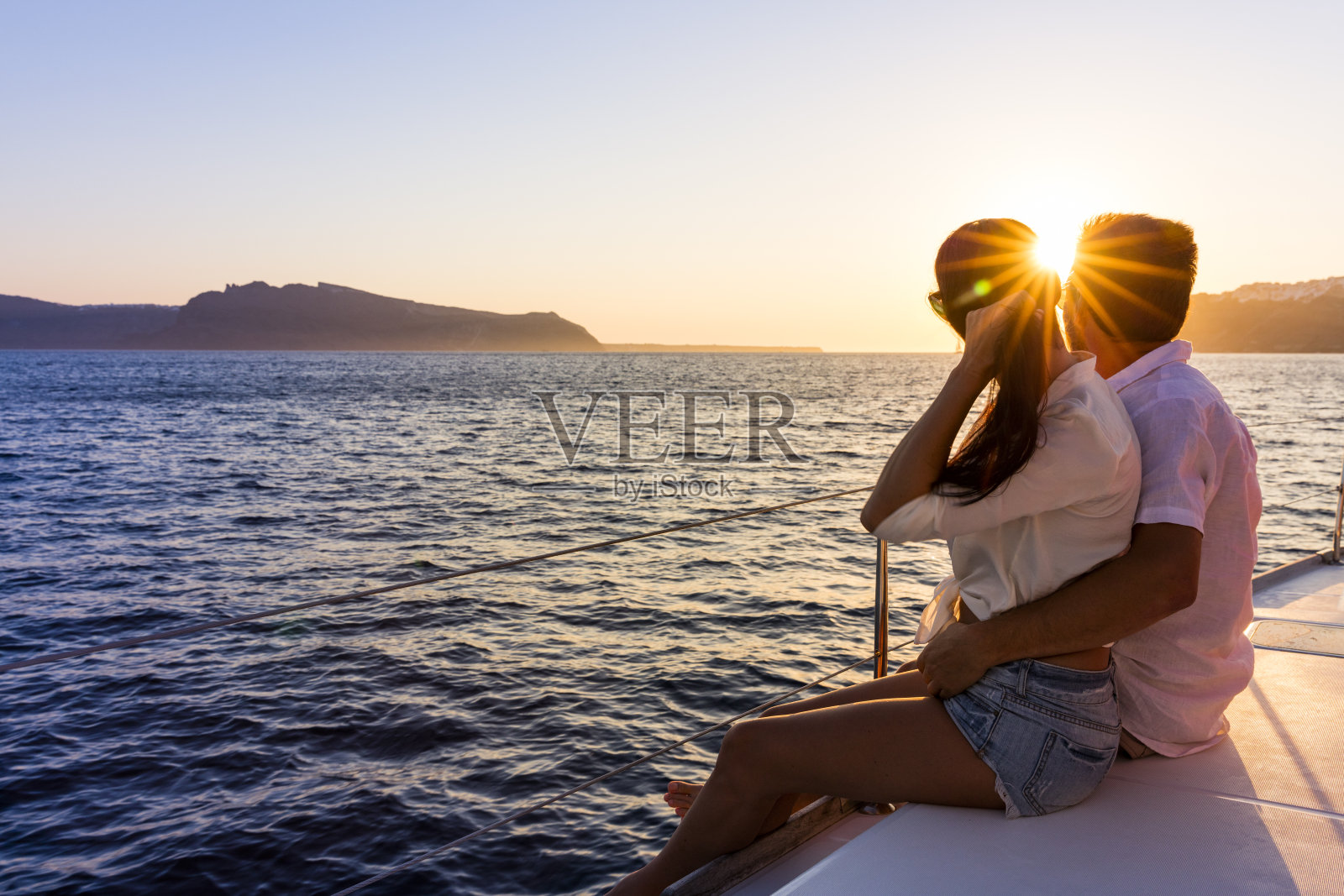 日落时分游艇上的浪漫情侣照片摄影图片