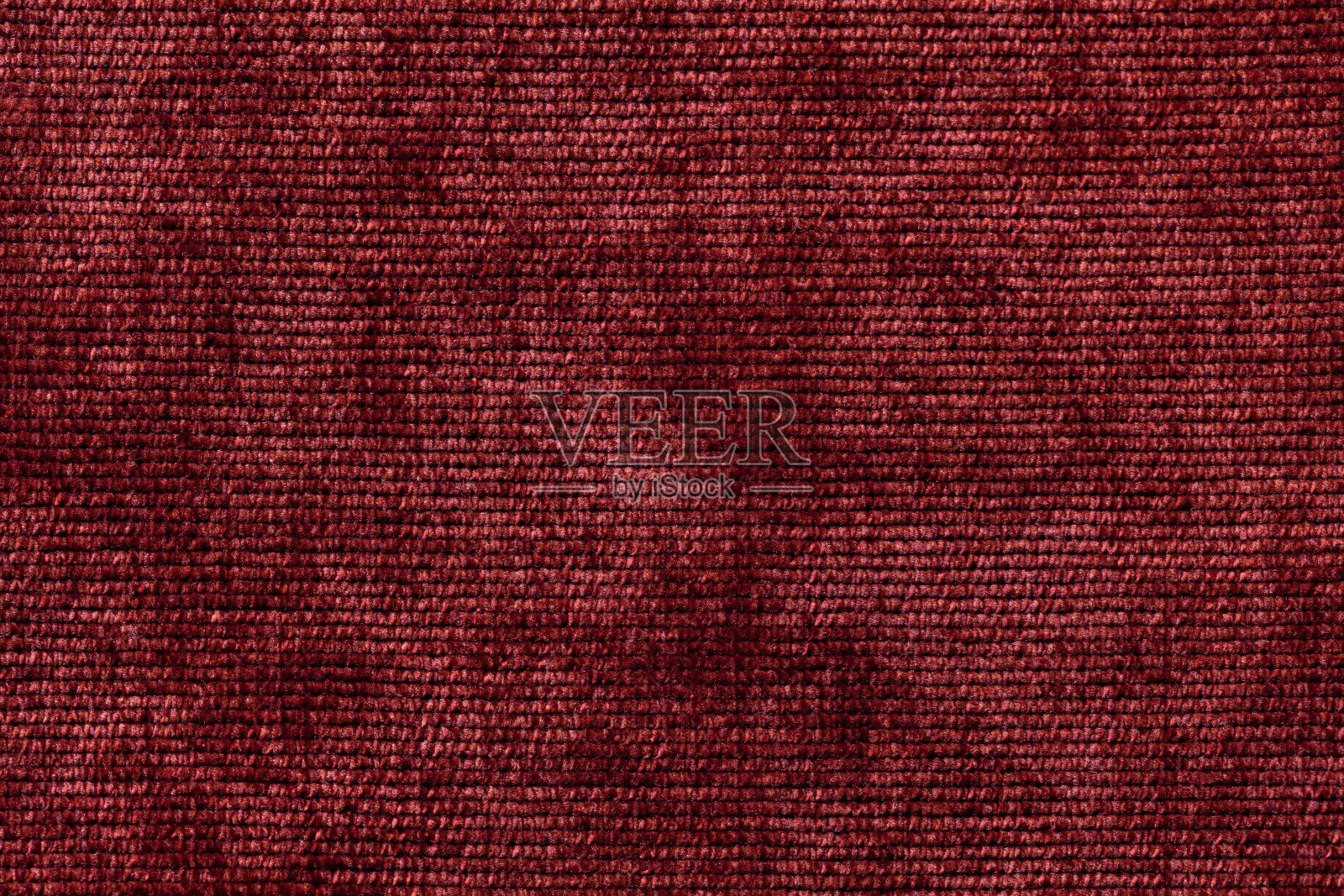 由柔软的纺织材料制成的深红色背景。照片摄影图片