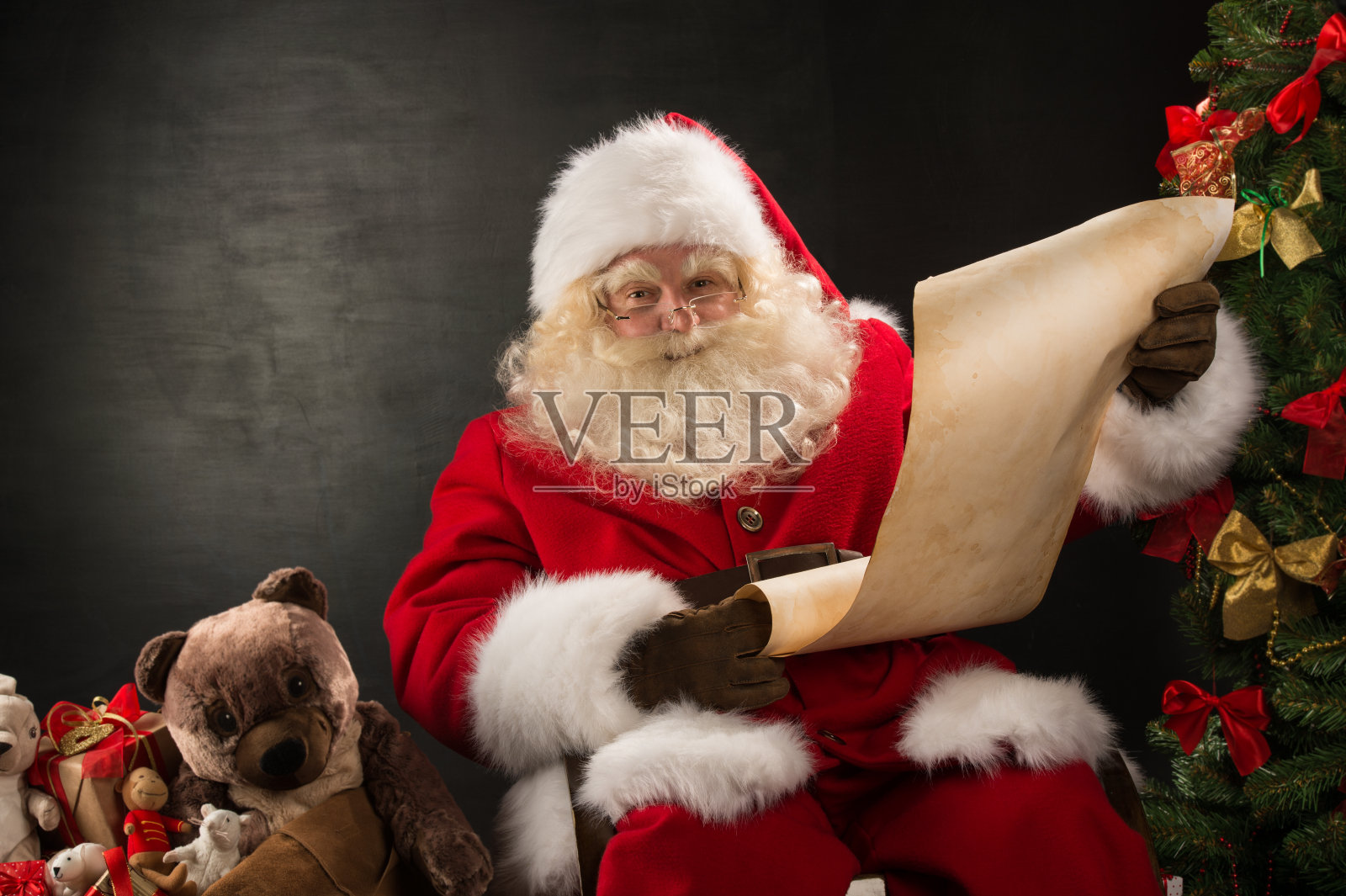 快乐的圣诞老人读圣诞信的肖像照片摄影图片