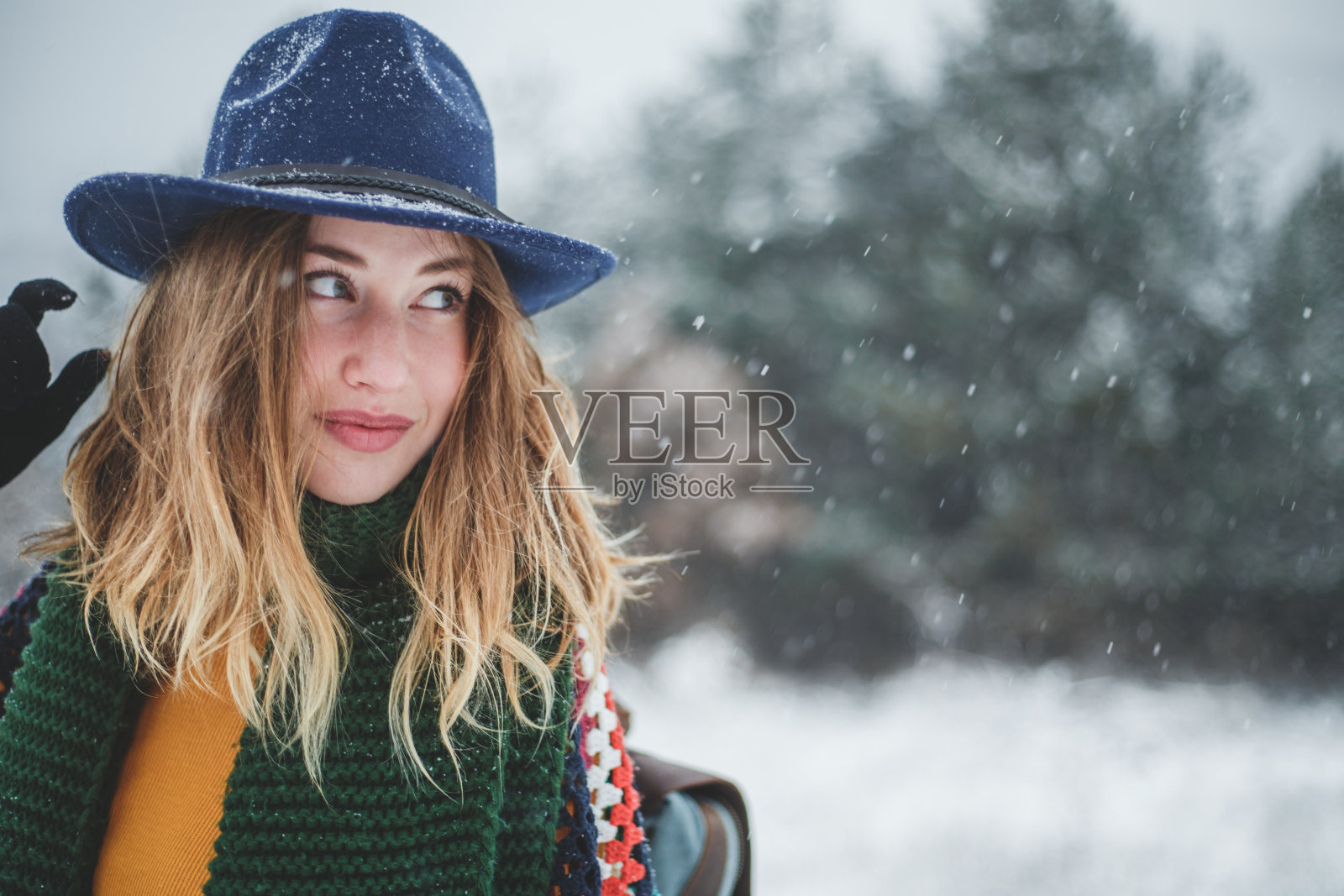 美丽的女孩与帽子和背包在冬天的一天照片摄影图片