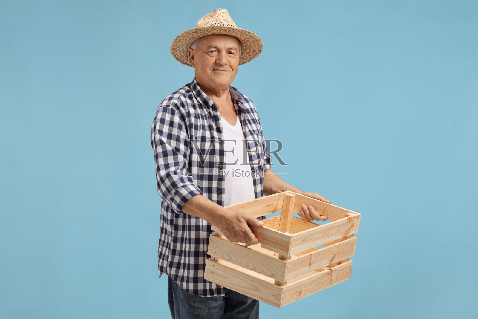 年迈的农民抱着一个空木箱子照片摄影图片