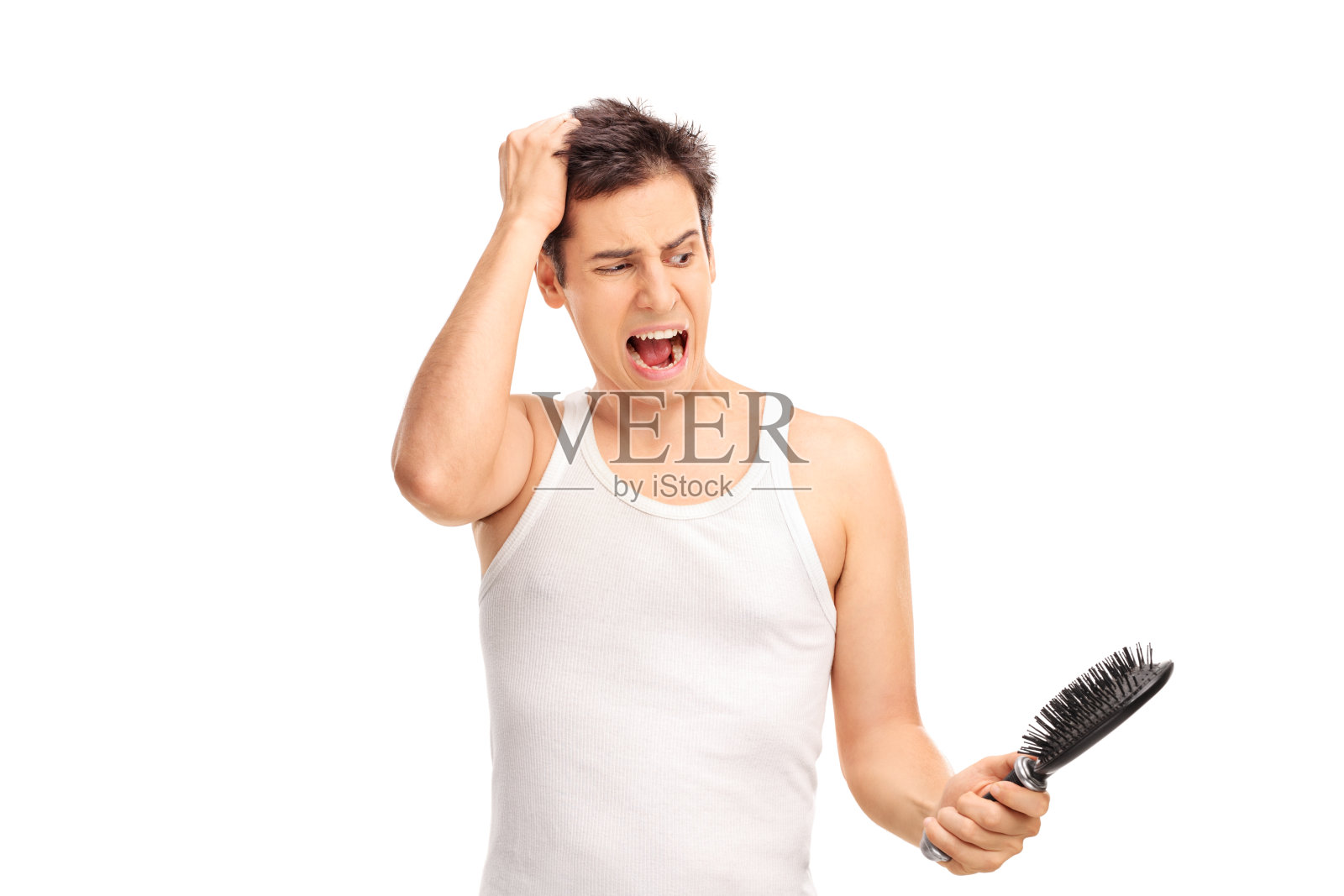 一个愤怒的男人拿着发刷，头发正在脱落照片摄影图片