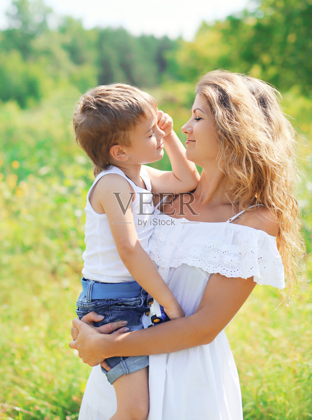 母亲拥抱孩子儿子在户外在夏天的肖像照片摄影图片