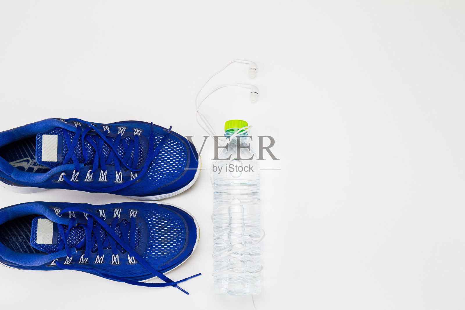 水瓶，运动鞋，白色背景的耳机照片摄影图片