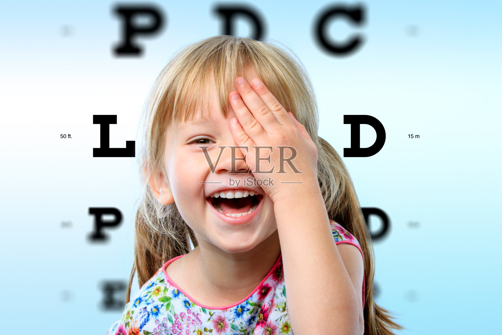 女孩对视力测试很感兴趣。照片摄影图片