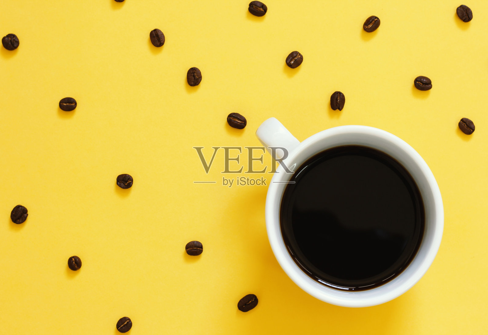 顶视图的黑咖啡和豆类在黄色的背景设计元素图片