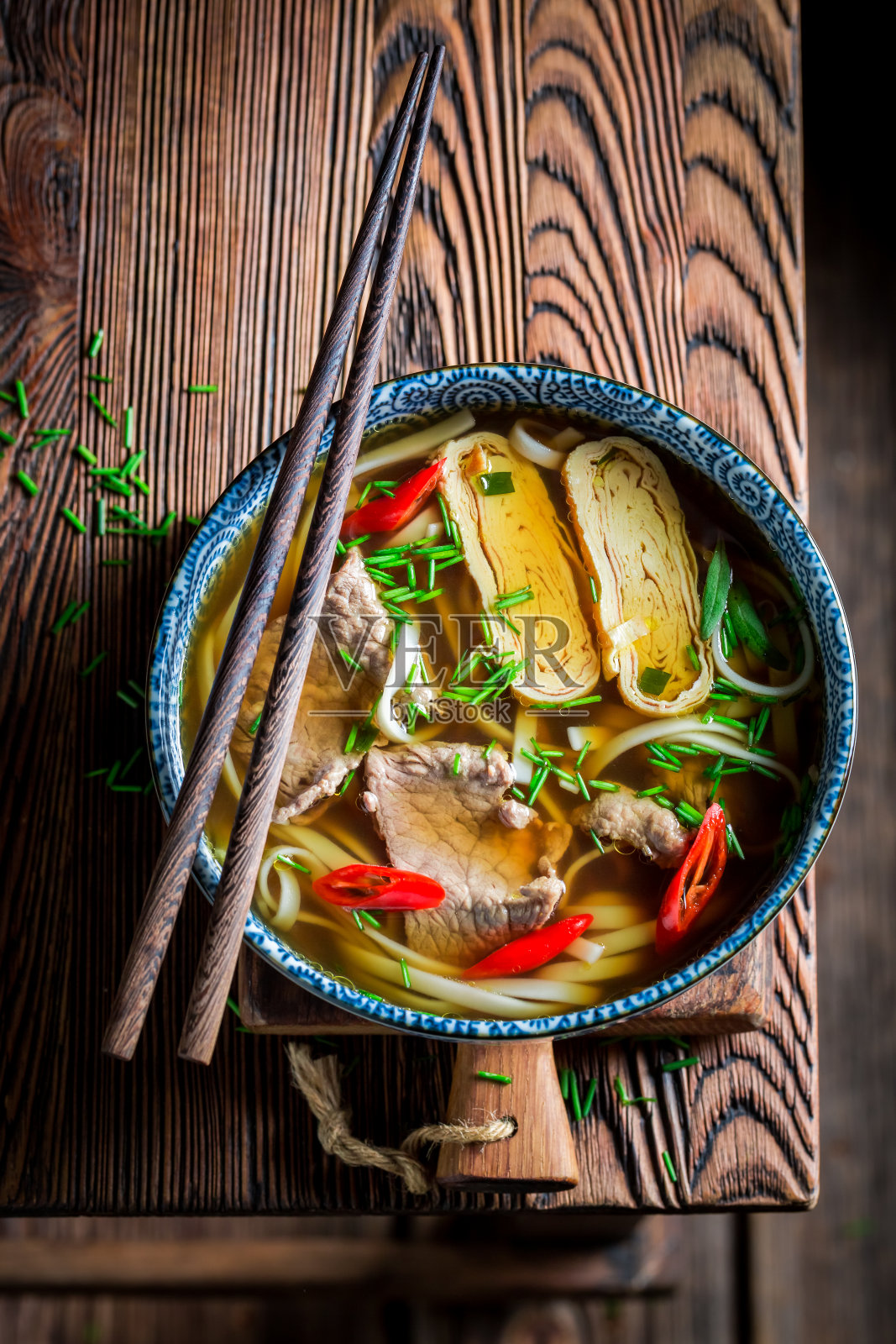美味的泰国肉汤在黑色的碗与筷子照片摄影图片