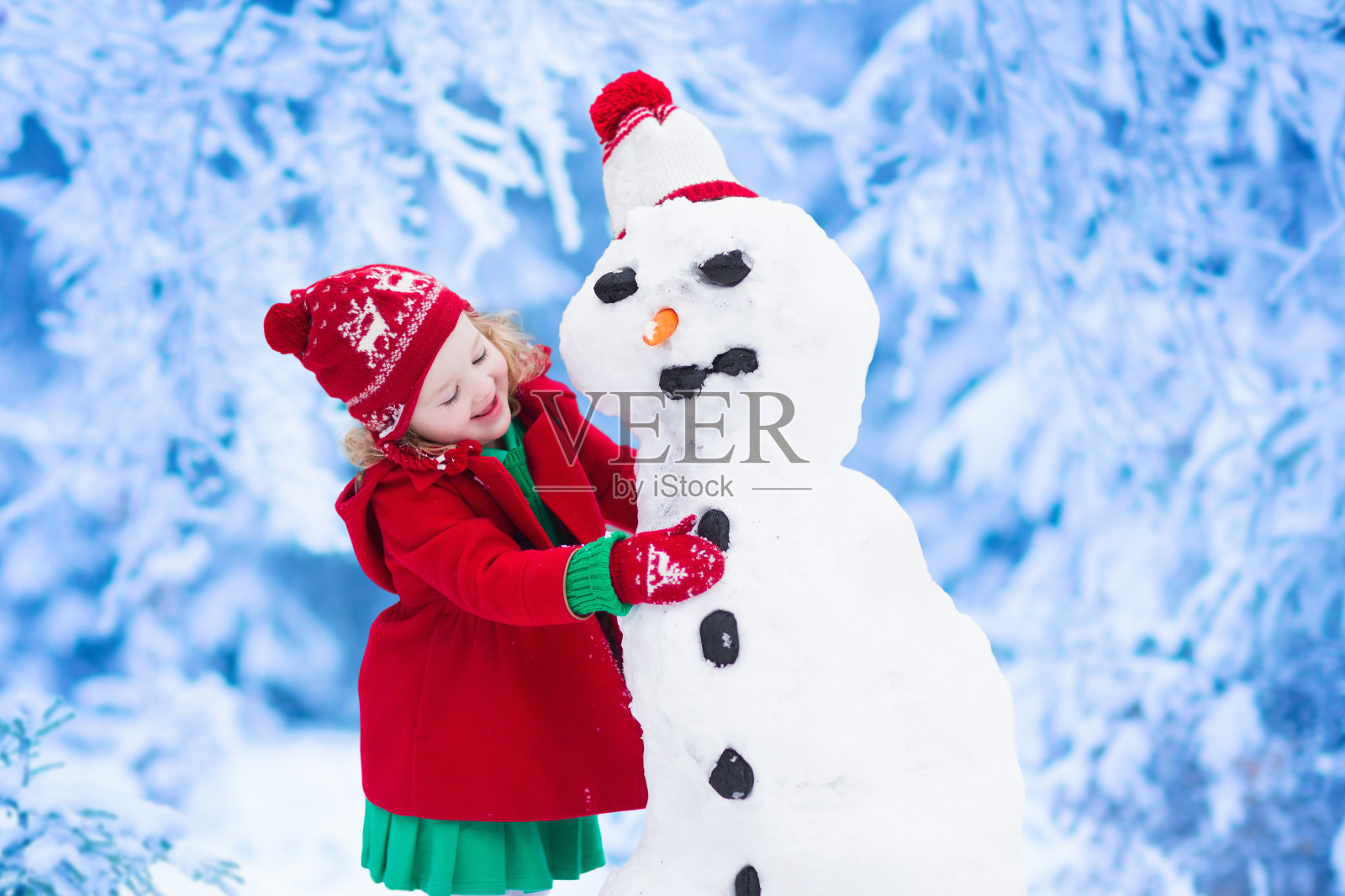 小女孩在冬天堆雪人照片摄影图片