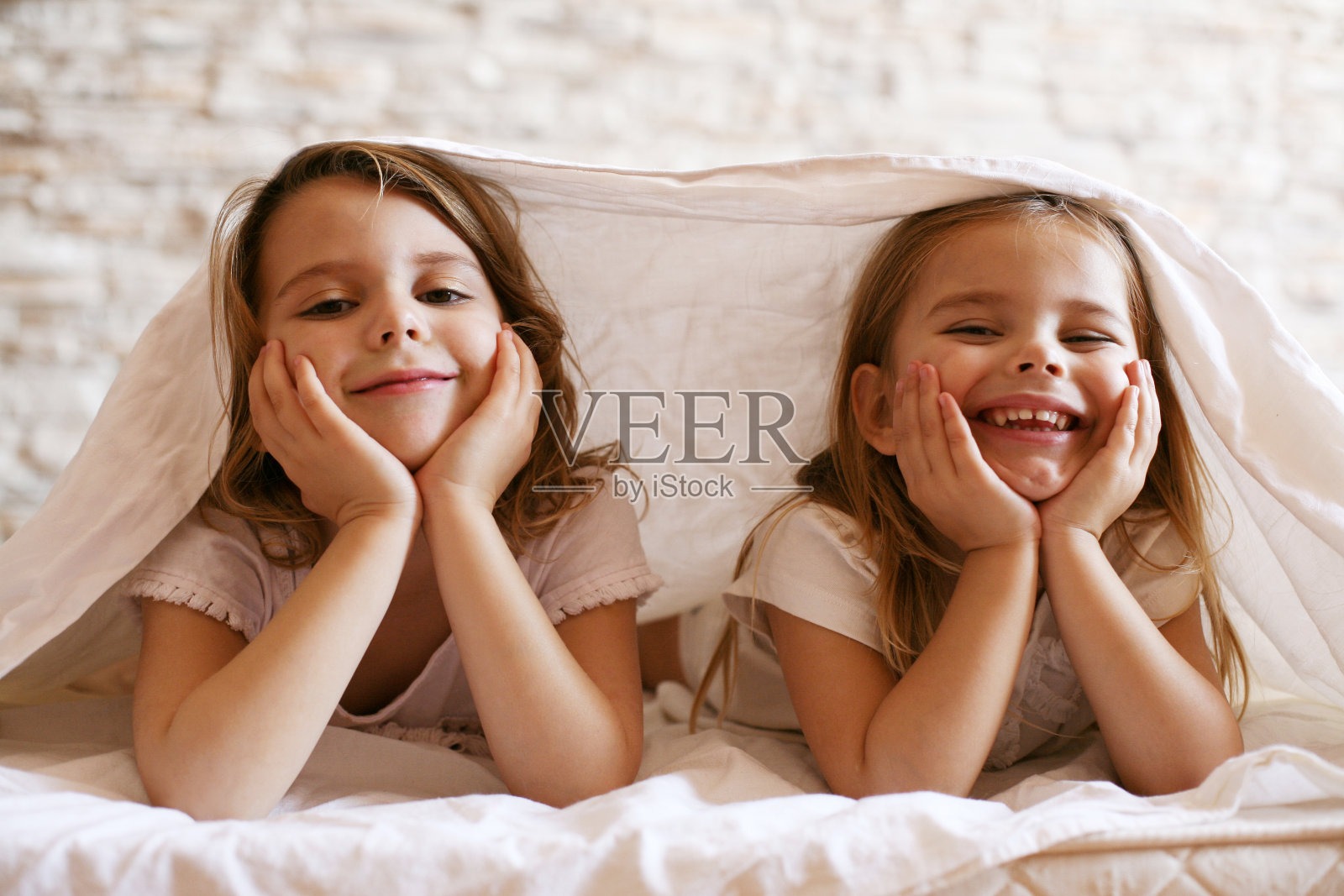 两个小女孩在床上。照片摄影图片