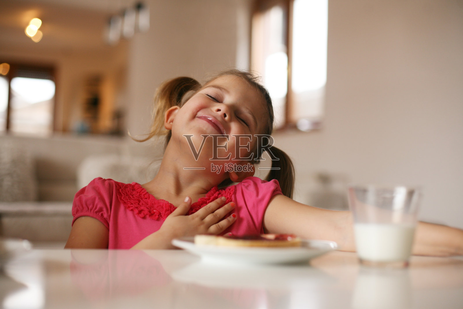 女孩吃早饭。照片摄影图片