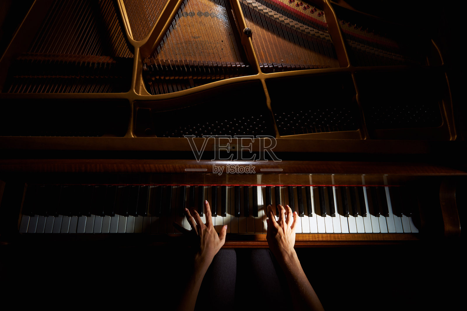 晚上女人的手放在钢琴键盘上照片摄影图片