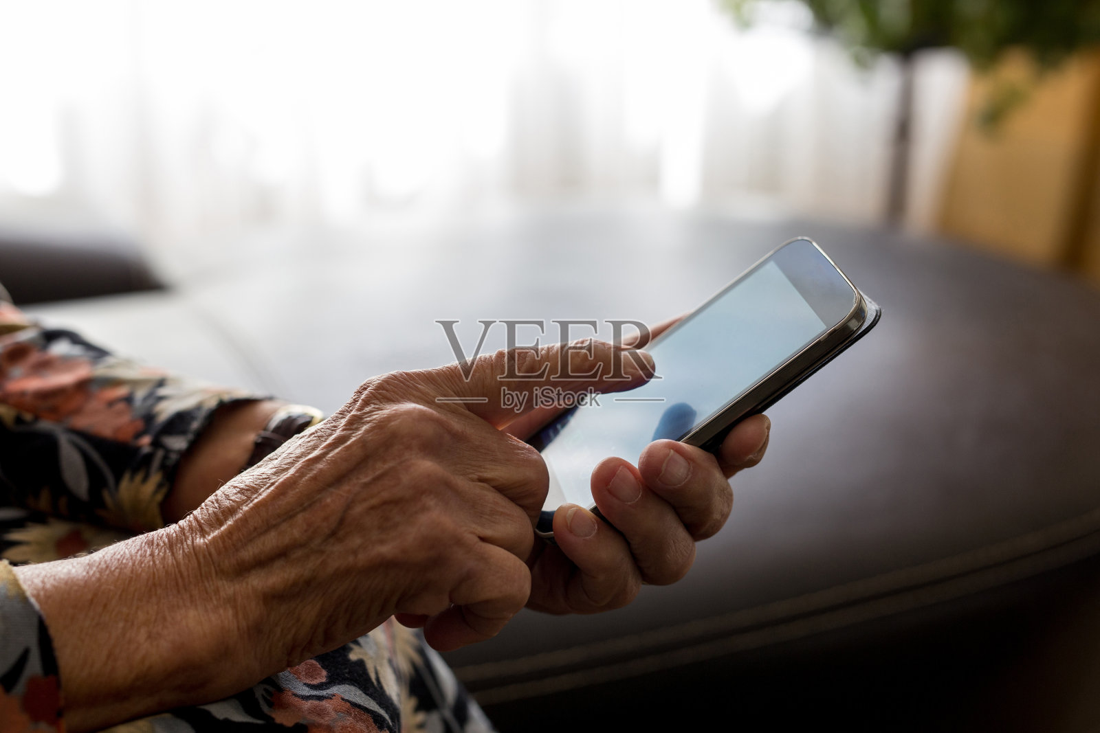 老妇人的手握手机的特写照片摄影图片