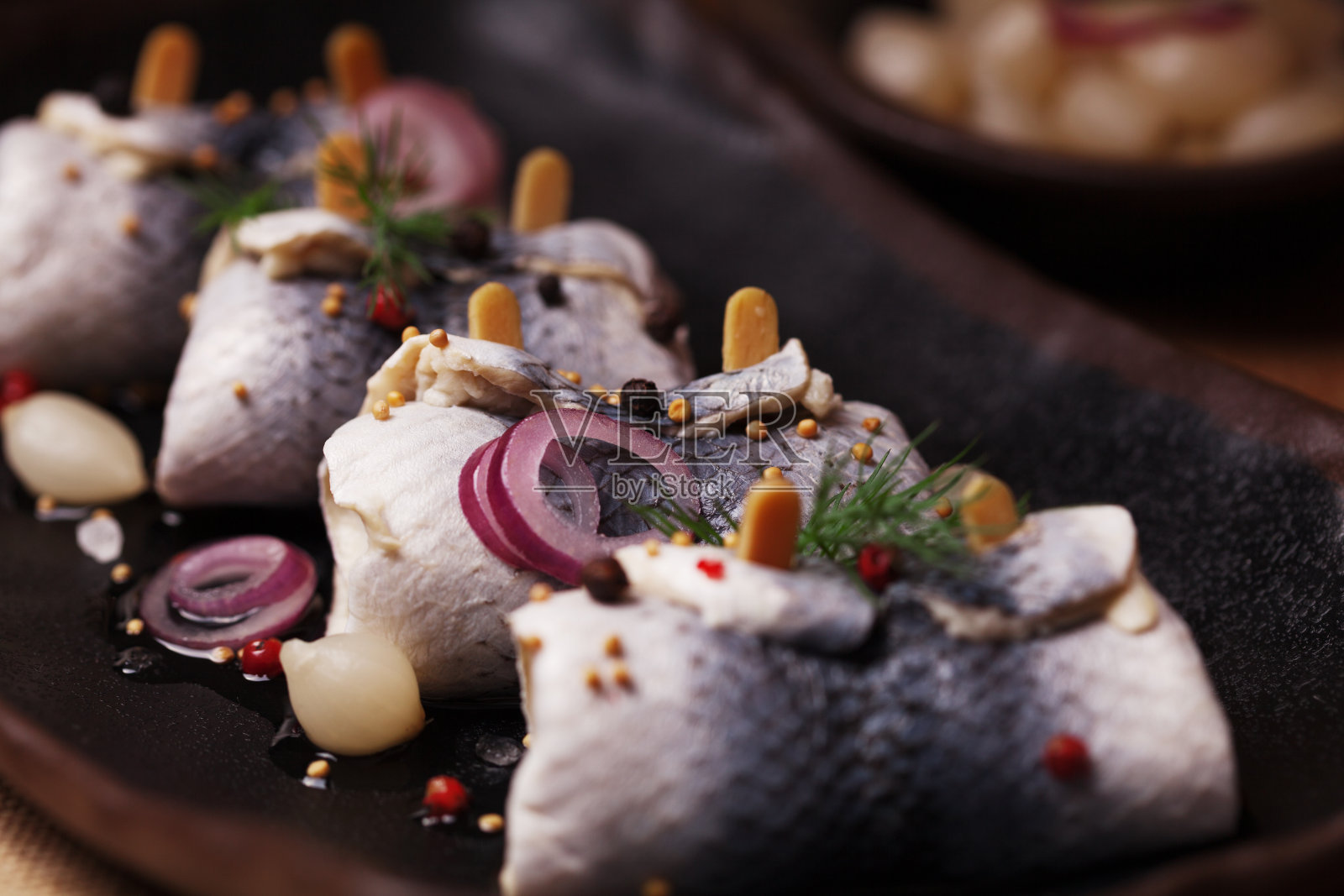 醋卷鲱鱼，与洋葱和泡菜一起食用。照片摄影图片