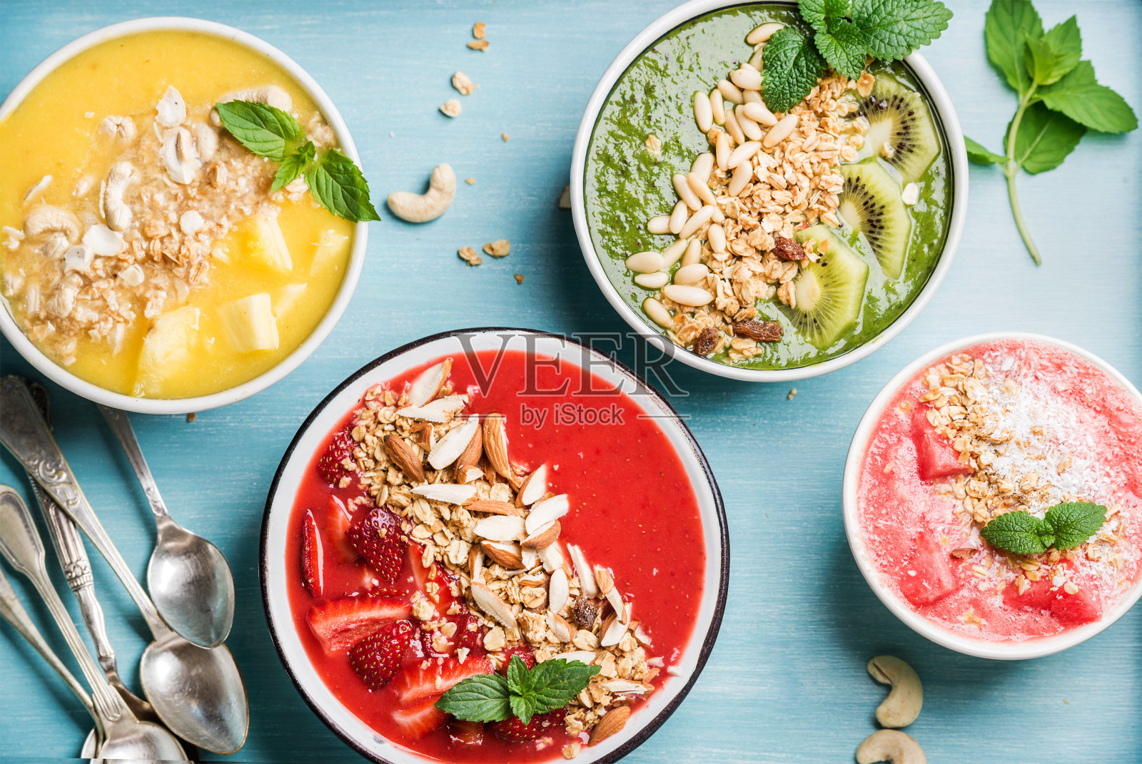健康的夏日早餐概念。绿松石色的彩色水果冰沙碗照片摄影图片