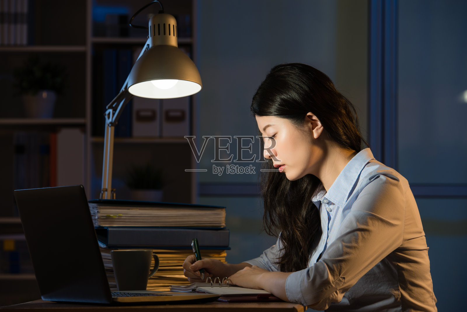 亚洲商务女性加班到深夜使用笔记本电脑照片摄影图片