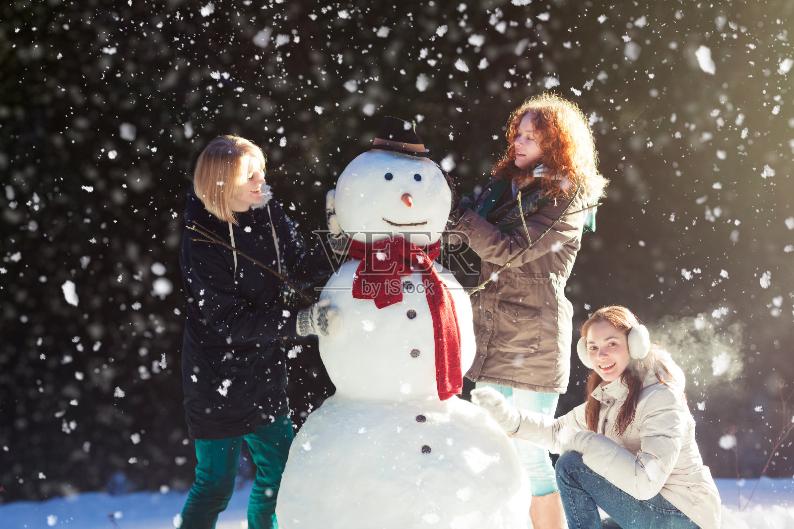 三个女孩在堆雪人照片摄影图片