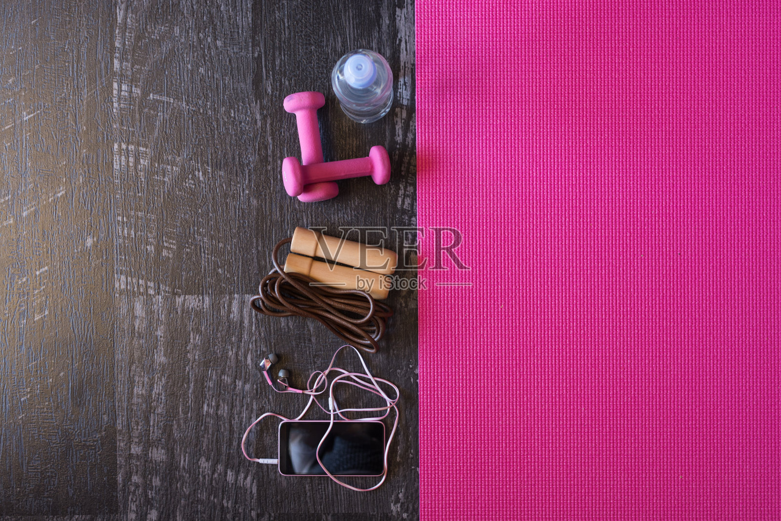 木制背景上的女性健身设备和粉色瑜伽垫照片摄影图片