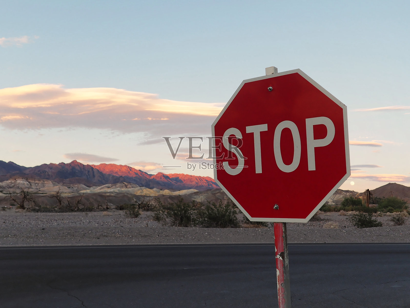 停止标志与日落背景在沙漠山脉照片摄影图片
