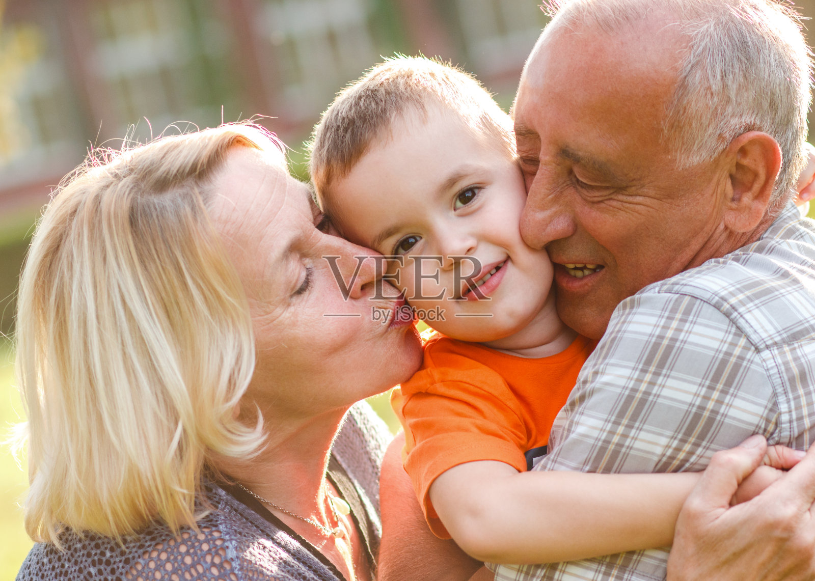 快乐的爷爷奶奶和孙子拥抱照片摄影图片