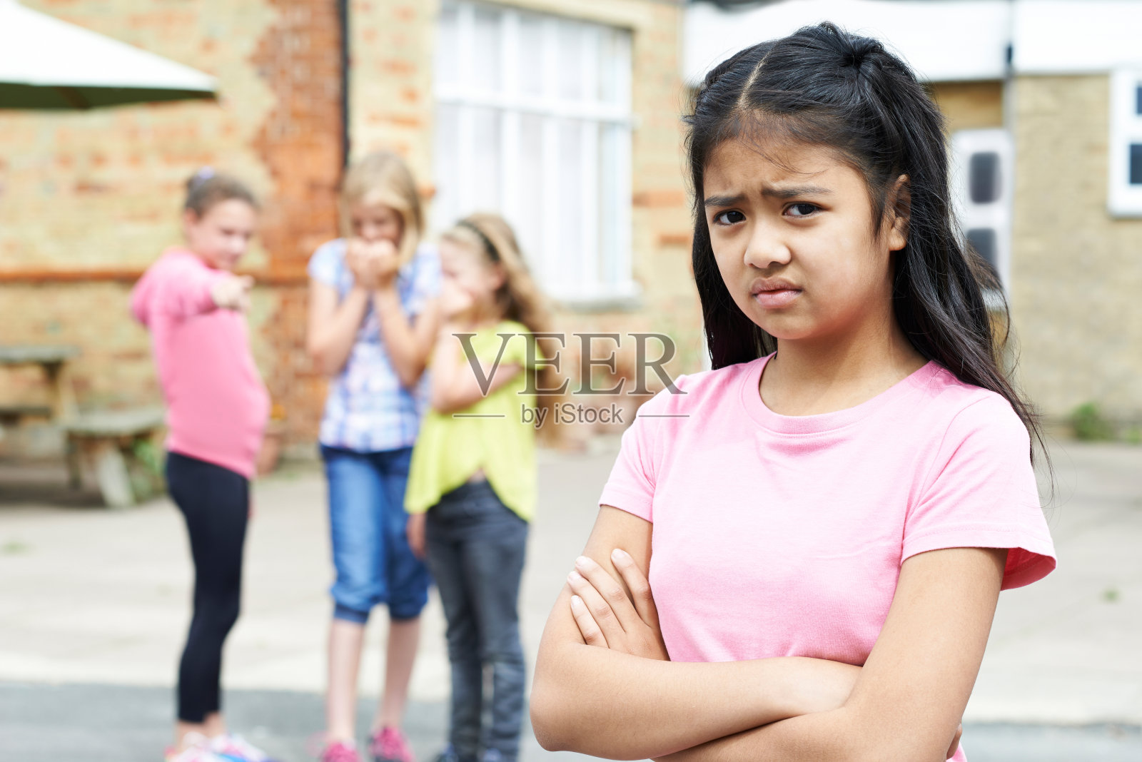 不开心的女孩被学校的朋友八卦照片摄影图片