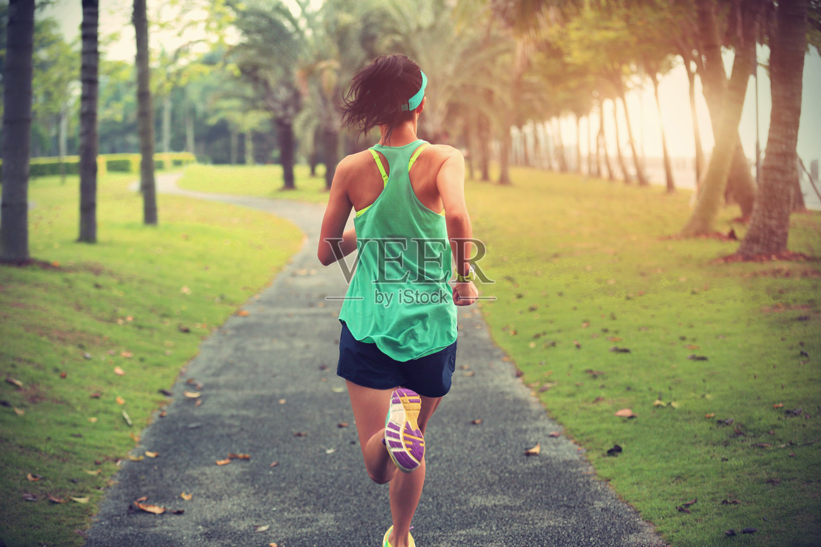 年轻的健身运动女性跑步热带公园小径照片摄影图片