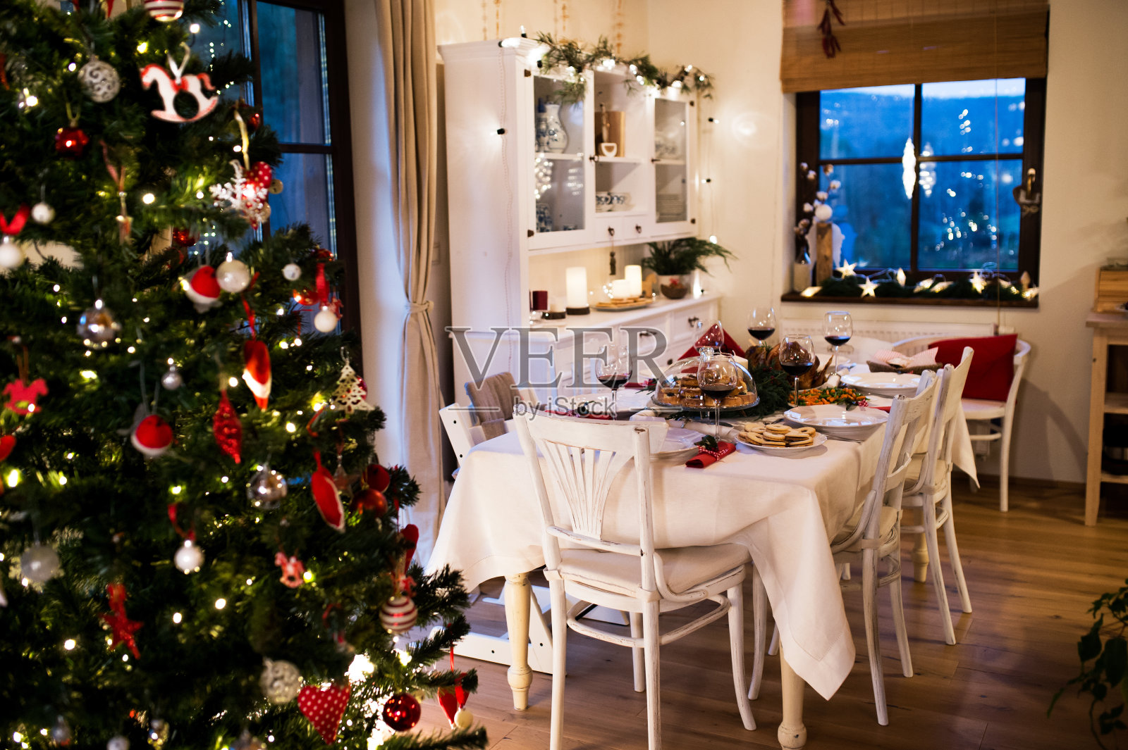 在装饰好的餐厅里，餐桌上摆着圣诞大餐。照片摄影图片
