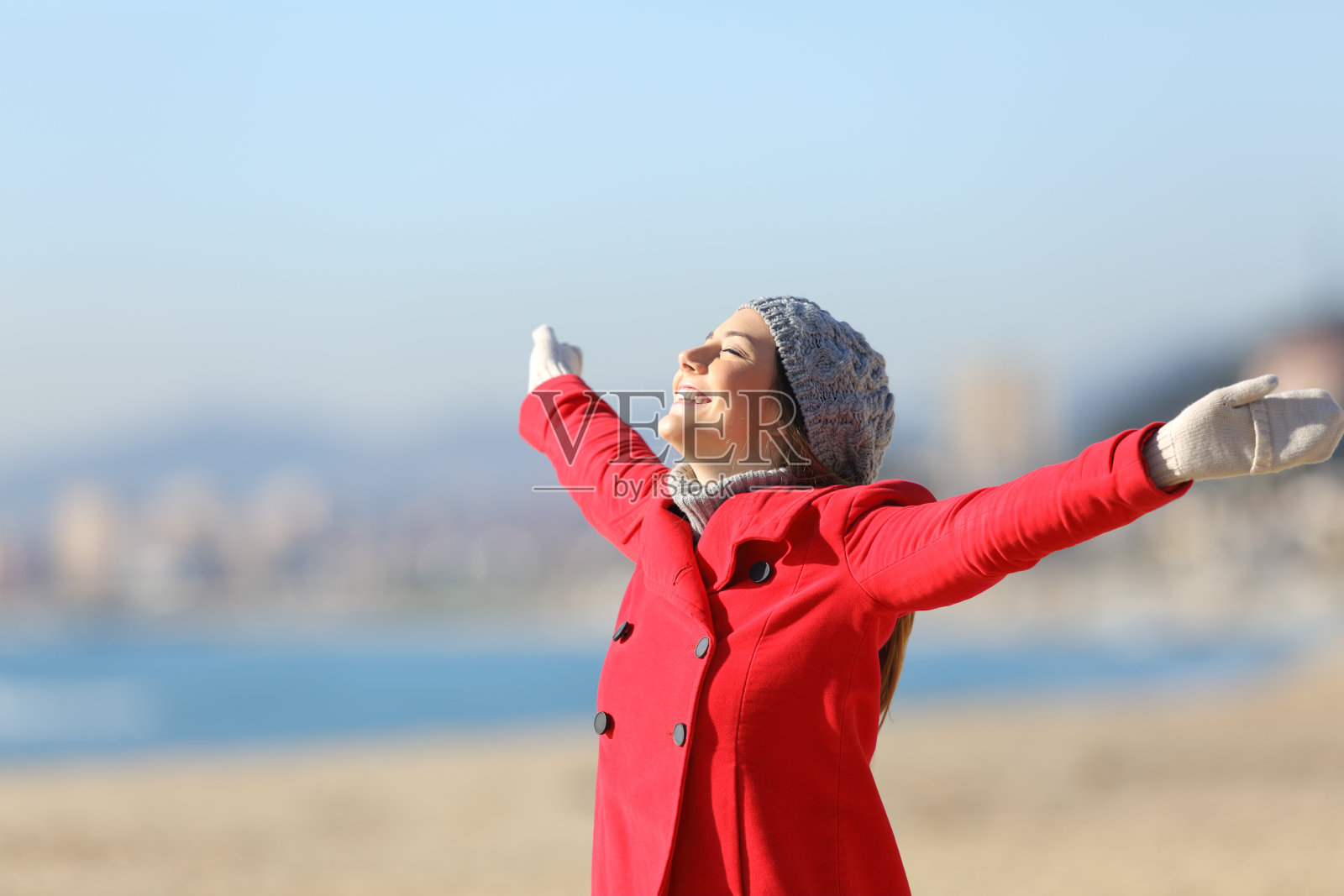 快乐的女人在冬天举起手臂呼吸照片摄影图片