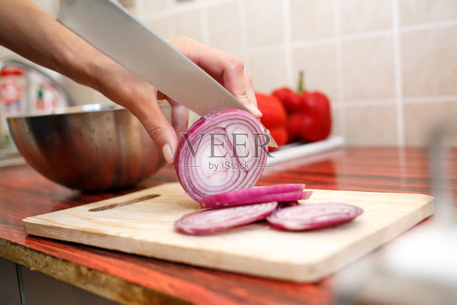 女人的手在切菜板上切红洋葱照片摄影图片