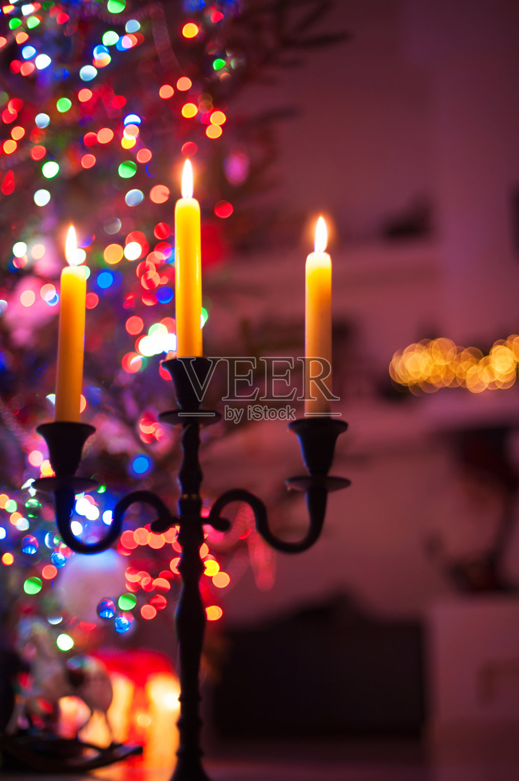 烛台与燃烧的火焰在照亮圣诞树的背景。照片摄影图片