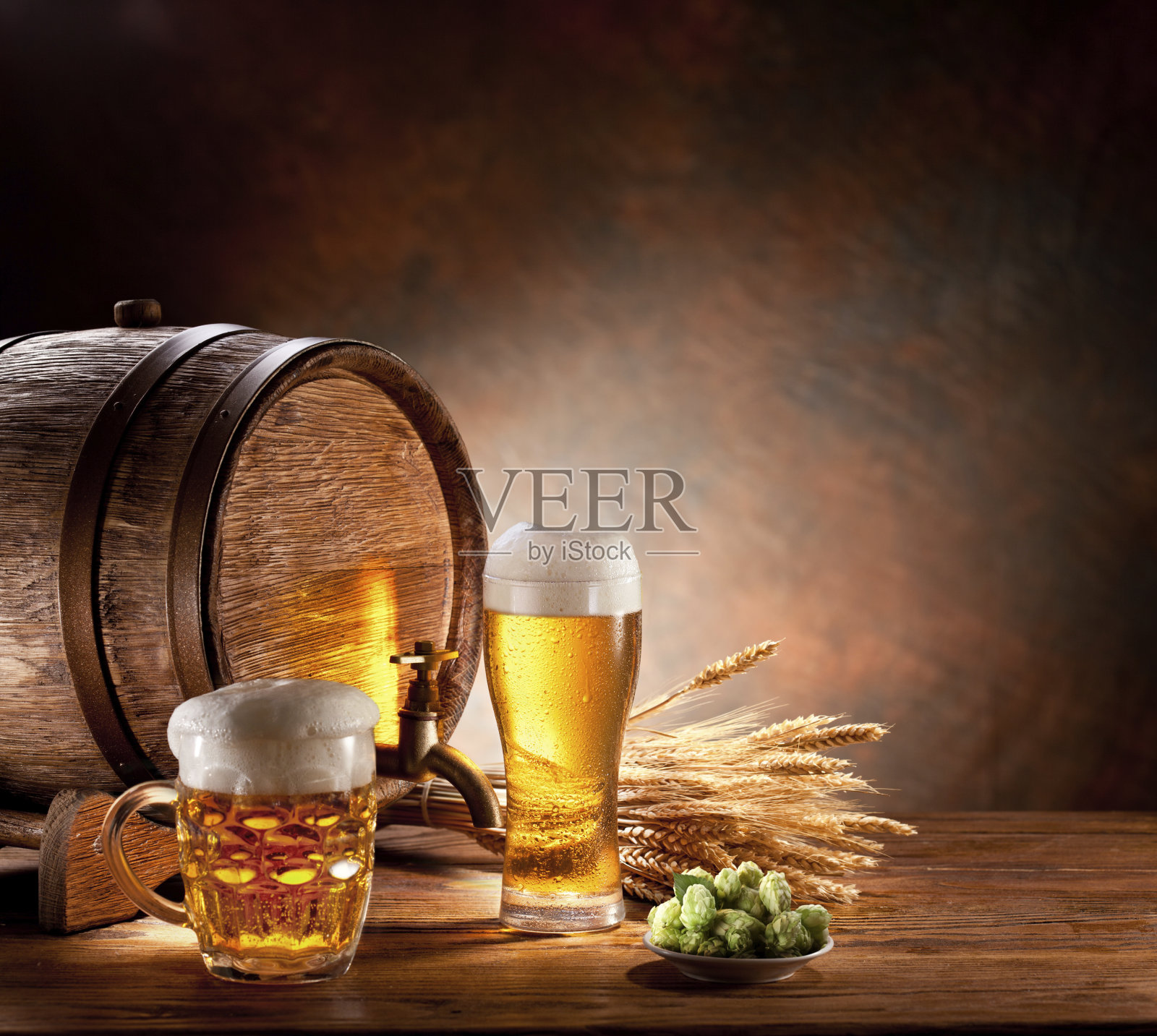 木桌上放着一桶啤酒和满杯的玻璃杯照片摄影图片
