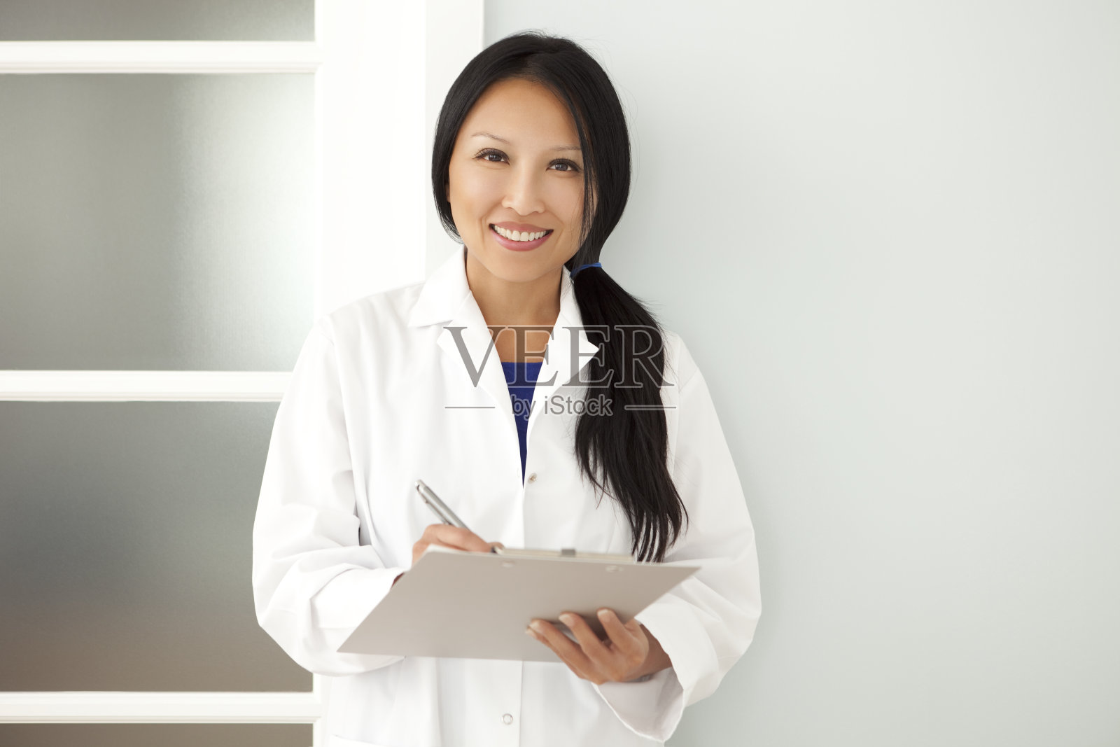 自信的亚洲女医生在写字板上做笔记照片摄影图片