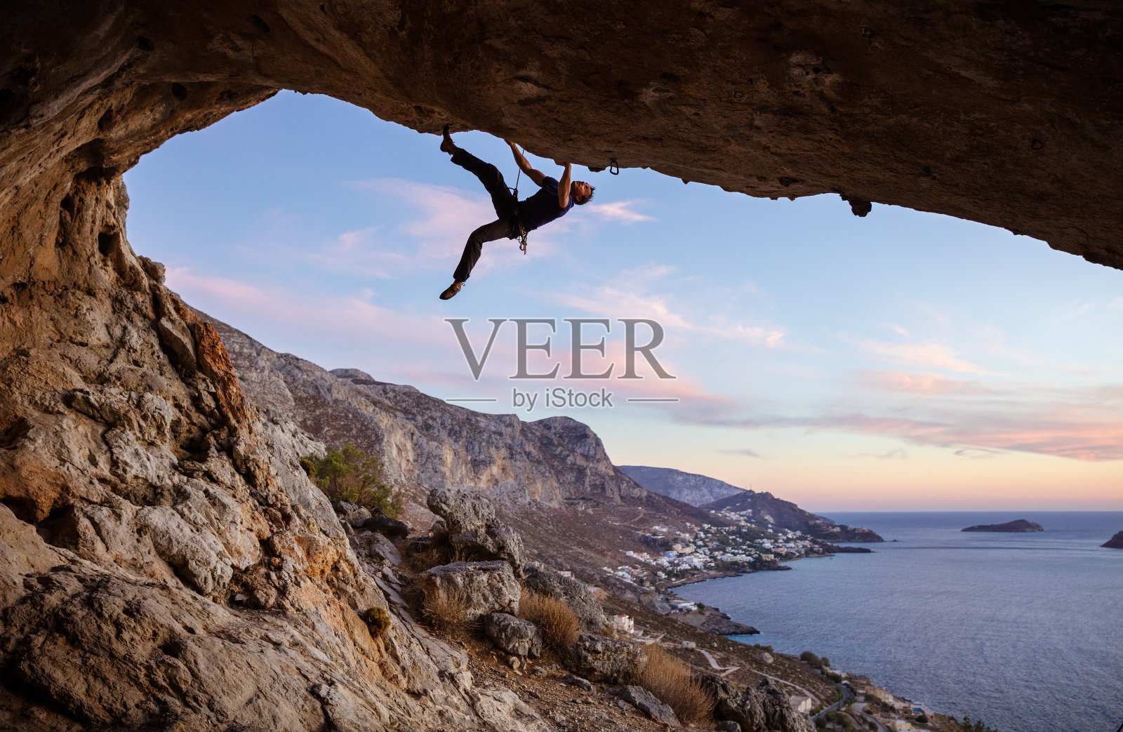 雄性攀登者沿着洞穴顶部攀登照片摄影图片